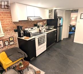Toronto (Dovercourt-Wallace Emerson-Junction) apartment for rent - A kitchen with a yellow chair and a black fridge.
