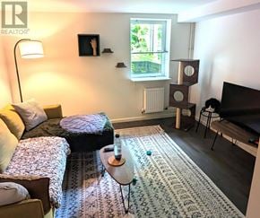 Toronto (Dovercourt-Wallace Emerson-Junction) apartment for rent - A living room with a couch, a chair, a coffee table, and a television.
