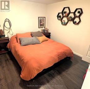 Toronto (Dovercourt-Wallace Emerson-Junction) apartment for rent - A bedroom with a bed covered in an orange sheet and pillows.