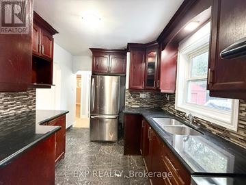 Toronto (Bendale) apartment for rent - A kitchen with dark wood cabinets and a stainless steel refrigerator.