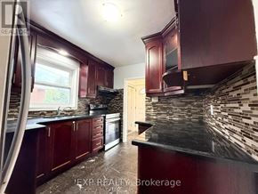 Toronto (Bendale) apartment for rent - A kitchen with dark wood cabinets and a black countertop.