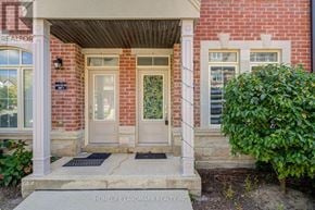 Toronto (L'amoreaux) townhouse for rent - A red brick house with a white door and a sign that says "HOMELIFE LANDMARK REALTY INC."