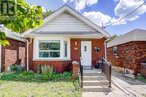 Toronto (Broadview North) apartment for rent - A small red brick house with a white door and a small front porch.