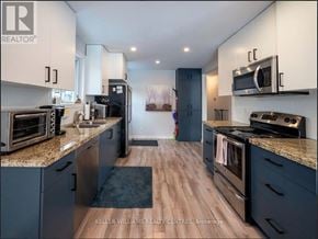 Newmarket (Huron Heights-Leslie Valley) apartment for rent - A modern kitchen with dark blue cabinets and stainless steel appliances.