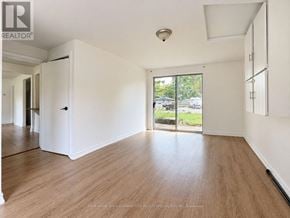 Vaughan (Maple) apartment for rent - A spacious room with wooden flooring and white walls, with a sliding glass door leading to a balcony.