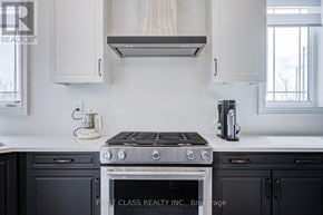 East Gwillimbury (Queensville) apartment for rent - A modern kitchen with a stove top oven and a coffee maker.