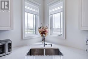 East Gwillimbury (Queensville) apartment for rent - A modern kitchen with a stainless steel sink and a microwave.