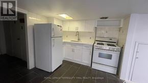 Toronto (Dovercourt-Wallace Emerson-Junction) triplex for rent - A kitchen with white appliances and cabinets.