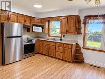 Milton (Mn Milton North) apartment for rent - A kitchen with wooden cabinets and a stainless steel refrigerator.