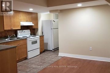 Mississauga (Churchill Meadows) apartment for rent - A kitchen with a white stove top oven and a white refrigerator.