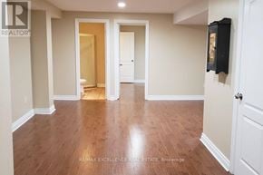 Mississauga (Churchill Meadows) apartment for rent - A spacious room with wooden flooring and white walls.