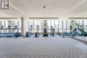 Mississauga (City Centre) condo for rent - A spacious gym with a variety of equipment including treadmills, elliptical machines, and weight machines.