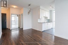 Mississauga (Creditview) condo for rent - A spacious room with wooden floors and white walls, featuring a kitchen area with white cabinets and a countertop.