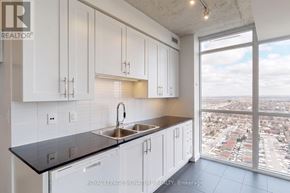 Mississauga (Creditview) condo for rent - A kitchen with white cabinets and a black countertop.
