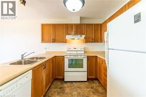 Waterloo townhouse for rent - A kitchen with wooden cabinets and a white stove top oven.