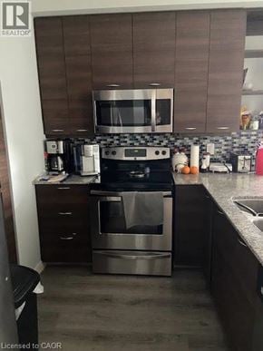 Waterloo condo for rent - A modern kitchen with a stainless steel oven and microwave.