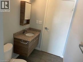 Waterloo condo for rent - A bathroom with a sink, toilet and a mirror.