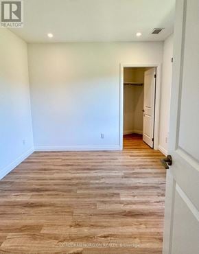 Kitchener condo for rent - A room with wooden flooring and a white door.