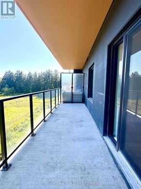 Kitchener condo for rent - A balcony with a view of trees and a building in the distance.