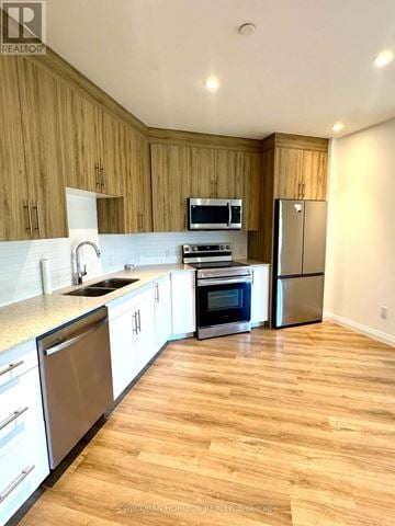 Kitchener condo for rent - A kitchen with wooden cabinets and stainless steel appliances.