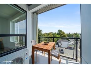Langley apartment for rent - A balcony with a table and chairs overlooking a parking lot.