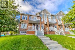 Ottawa condo for rent - A two-story brick house with a front porch and a green lawn.