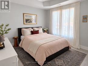 Oshawa (O'neill) multi-family for rent - A bedroom with a large bed and a painting on the wall.