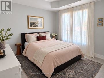 Oshawa (O'neill) multi-family for rent - A bedroom with a large bed and a painting on the wall.