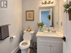 Oshawa (O'neill) multi-family for rent - A bathroom with a toilet, sink, and mirror.