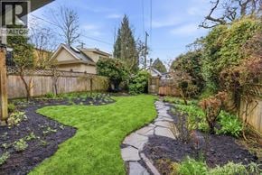 Vancouver apartment for rent - A backyard with a stone pathway and a wooden fence.
