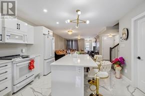 Azilda apartment for rent - A white kitchen with a marble countertop and a white island.