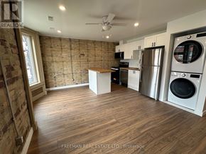 Toronto (South Riverdale) apartment for rent - A kitchen with wooden floors and a brick wall.