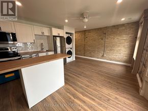 Toronto (South Riverdale) apartment for rent - A kitchen with wooden floors and a brick wall.