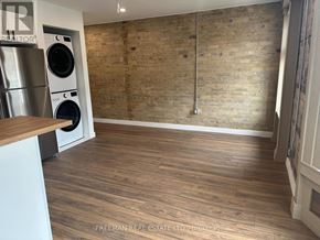 Toronto (South Riverdale) apartment for rent - A room with wooden flooring and a brick wall.