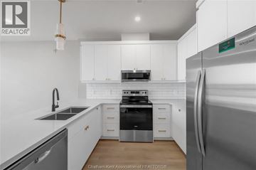 Blenheim apartment for rent - A modern kitchen with white cabinets and stainless steel appliances.