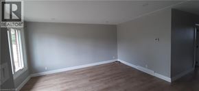 Kitchener apartment for rent - A large empty room with wooden floors and white walls.