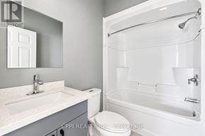 Fort Erie (Central) condo for rent - A white bathroom with a sink, toilet, and bathtub.