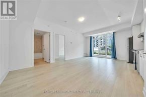 Markham (Wismer) condo for rent - A spacious room with wooden flooring and white walls, with a view of a building outside the window.