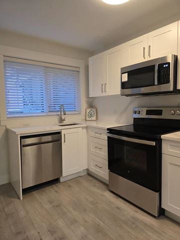 Mission apartment for rent - A kitchen with a black microwave above a stove.
