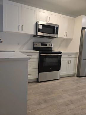 Mission apartment for rent - A kitchen with a stove top oven and microwave above it.