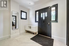 Toronto (Willowdale West) apartment for rent - A black door is in a white room with a mirror and a bench.