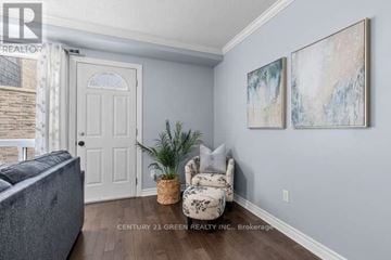 London South (South Q) townhouse for rent - A living room with a grey couch, a plant, and two paintings on the wall.