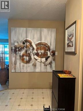 Windsor condo for rent - A reception area with a large artwork on the wall and a small table with a basket on it.