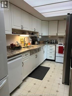 Windsor condo for rent - A kitchen with white cabinets and a black mat on the floor.
