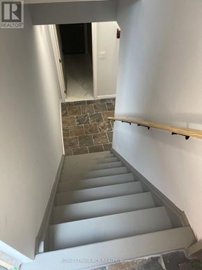 Caledon (Bolton North) apartment for rent - A staircase with a wooden handrail and stone steps.