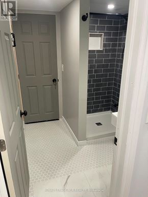 Caledon (Bolton North) apartment for rent - A bathroom with a white tile floor and a grey door.