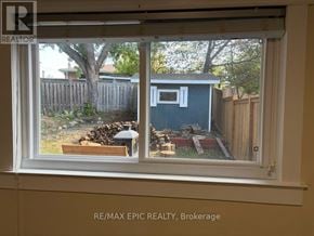 Mississauga (Erindale) apartment for rent - A window with a view of a backyard with a shed and a tree.