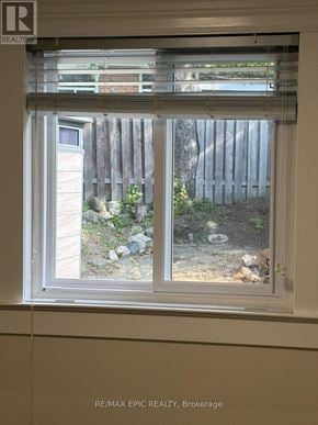 Mississauga (Erindale) apartment for rent - A window with a view of a backyard with a fence and plants.