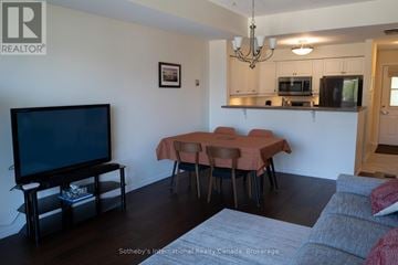 Collingwood townhouse for rent - A living room with a television, a dining table and chairs, and a couch.