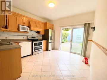 Toronto (Little Portugal) townhouse for rent - A kitchen with wooden cabinets and appliances.